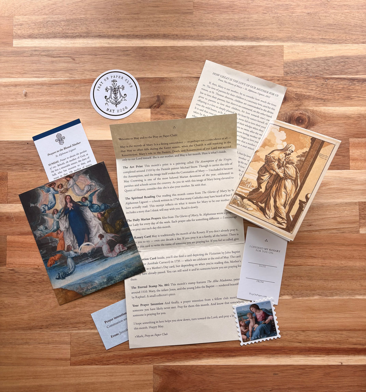 Full spread of items inside a Pray on Paper Club monthly Catholic prayer envelope